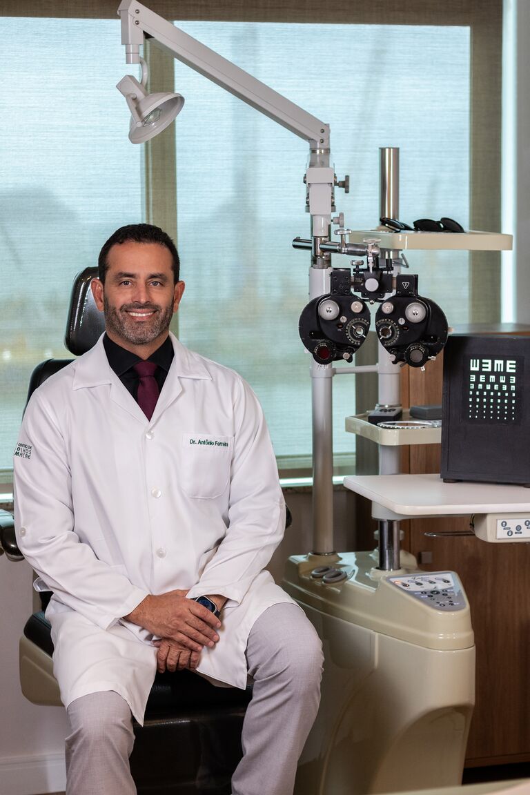 Dr. Antônio Ferreira Leite Jr. ajustando o refrator durante um exame de refração